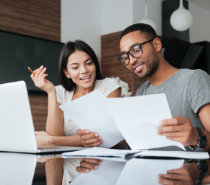 young couple looking over finances at a table